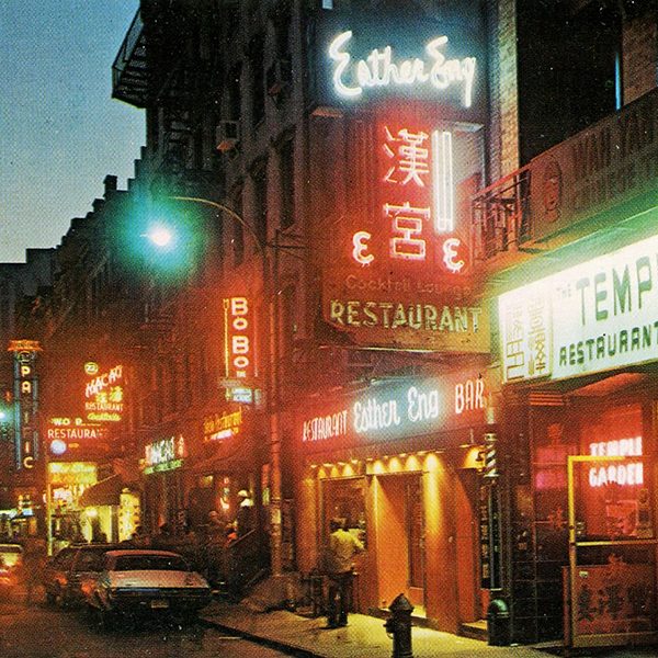 A vintage chinatown street scene with brightly colored neon signs.