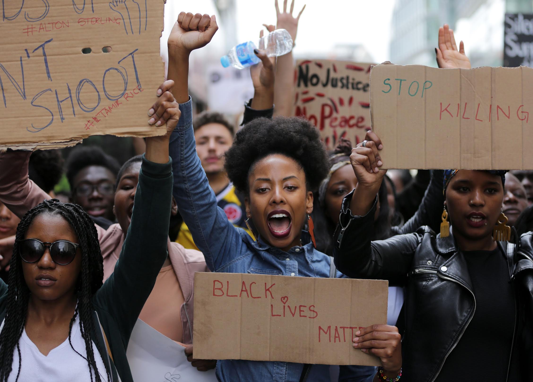 photograph of a protesters holding signs and raising their fists during a Black Lives Matter protest