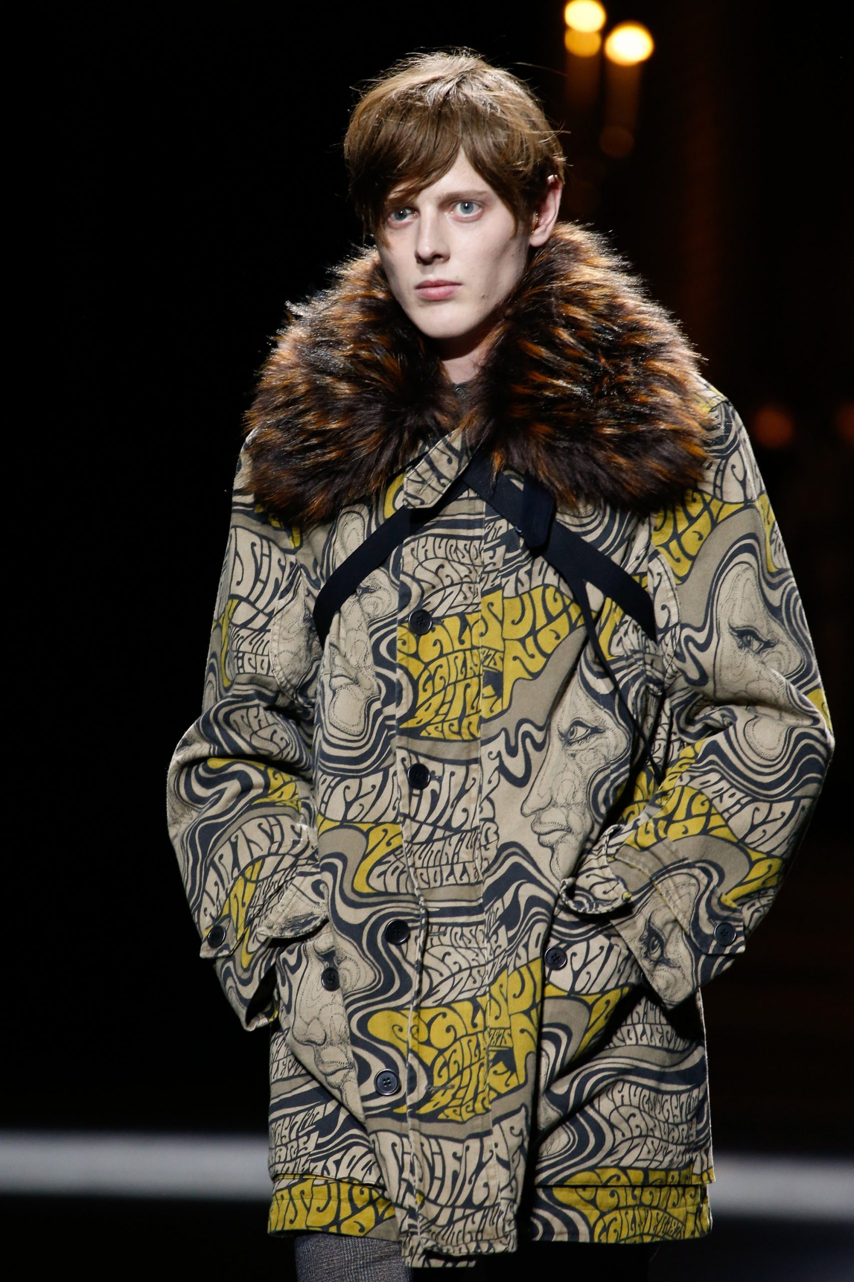 photograph of a male model walking a runway wearing a psychedelic era inspired coat