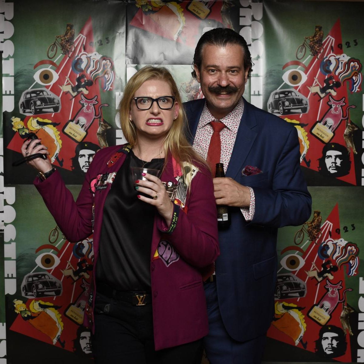 A blonde woman making a funny face next to an older mustachioed man.