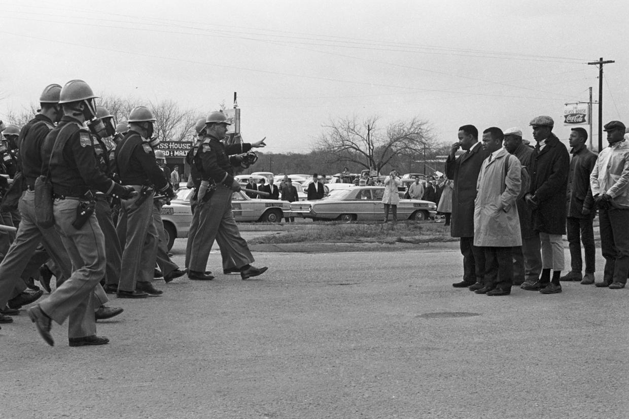 Local police and state troopers walk towards the Selma marchers, including John Lewis, moments before the acts that led to the date being immortalized as 