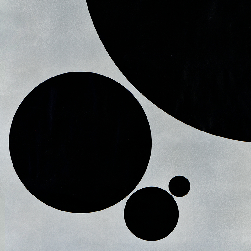 A cropped illustrational poster of four black circles of various sizes on a gray background.