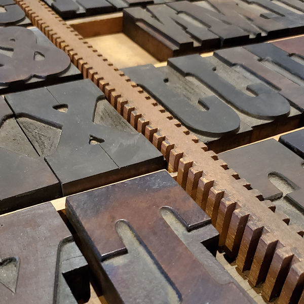 a close-up photograph of wood-type lettering in a storage drawer