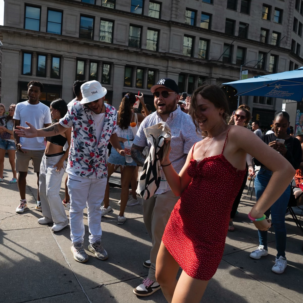 A group of people dance in an open plaza