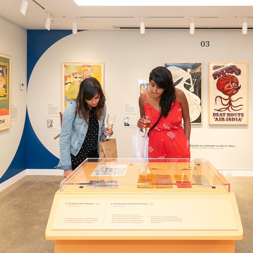 A photo of two women looking at a display in an art gallery.
