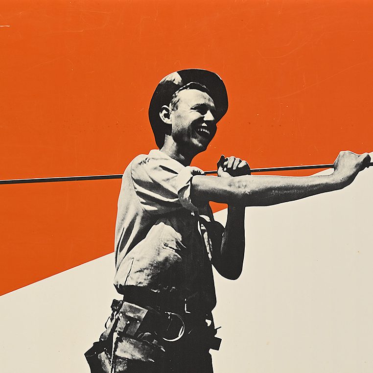 A man with an electrical wire stands in the foreground of an orange sky