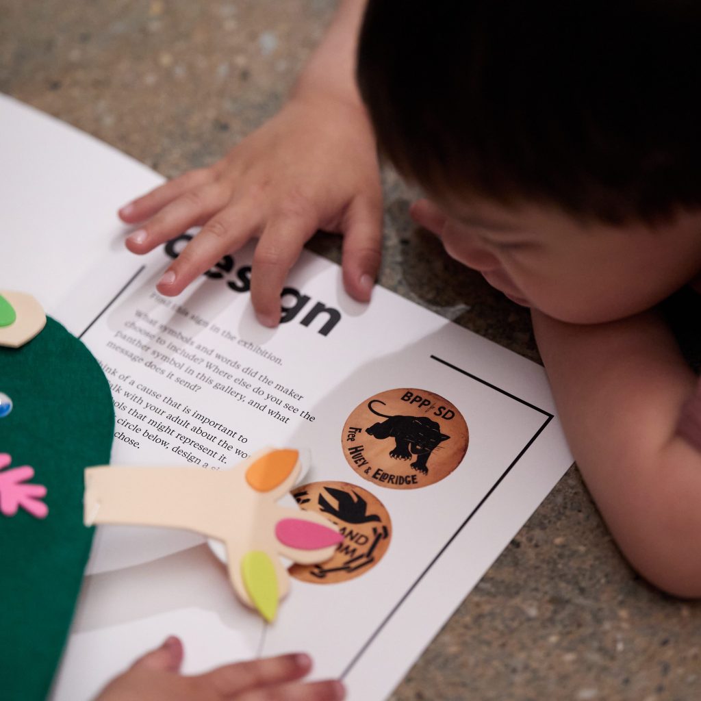 A small child looks at writing on a flyer