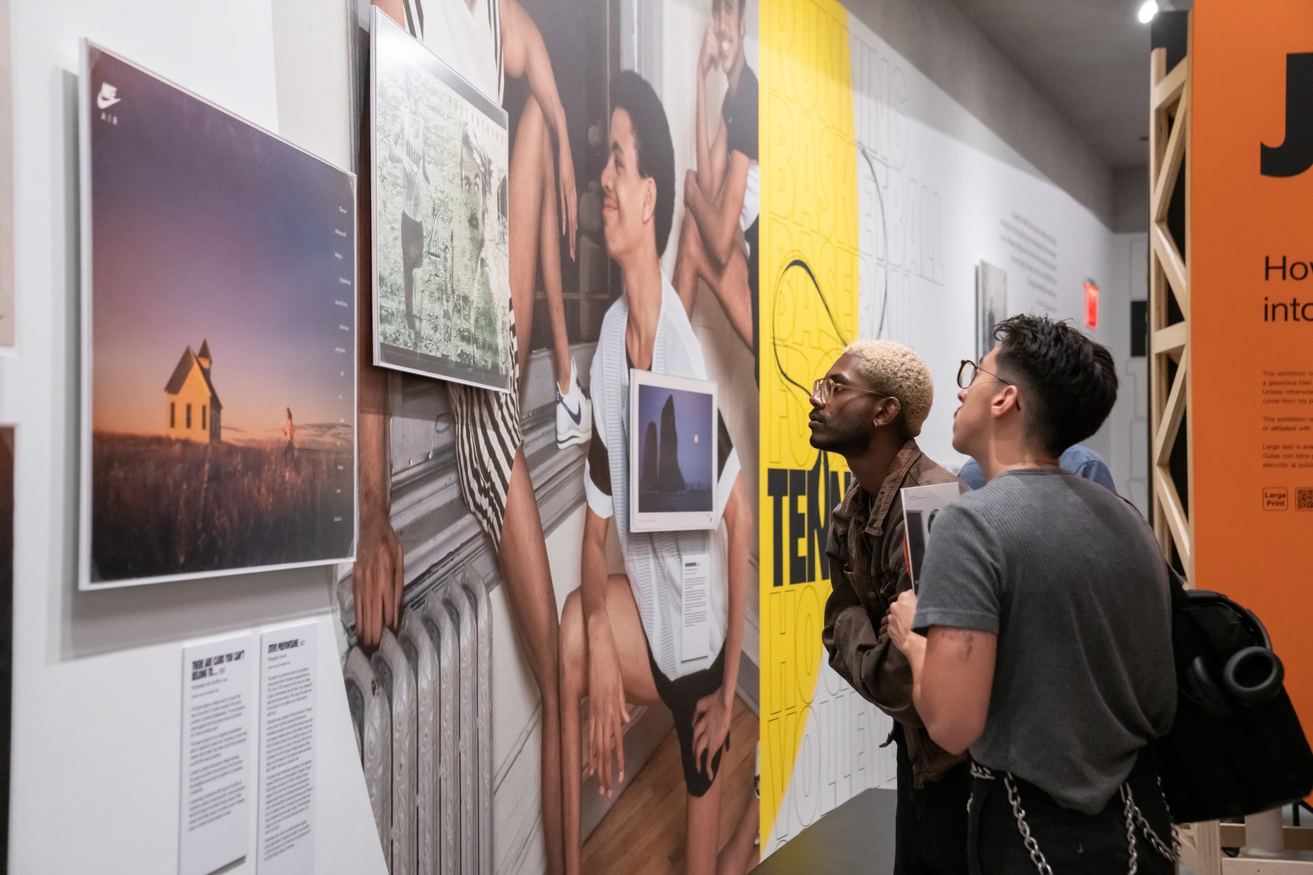 A couple of friends enjoying membership perks in the gallery at Poster House.