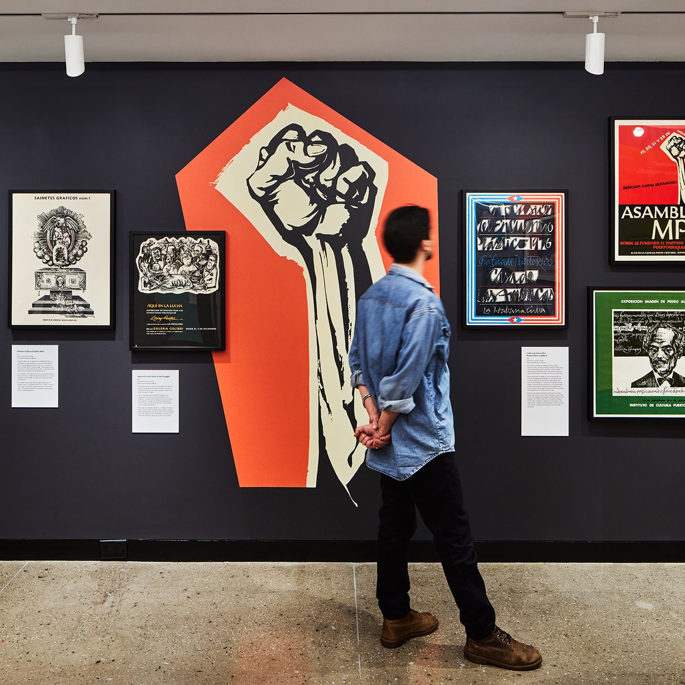 A photo of a man walking through a museum gallery