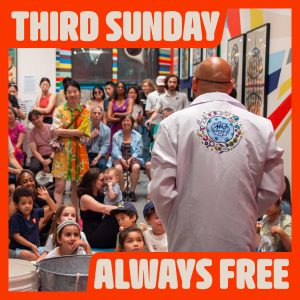 Digital image of a man wearing a lab coat standing looking out over an audience of children and their parents.
