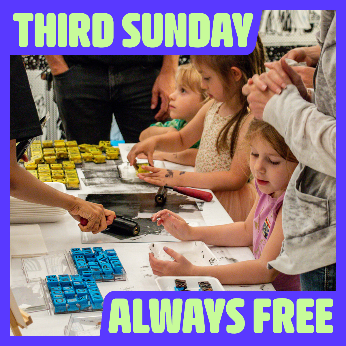 Digital image of three children standing at a table making prints using letterpress letters at an art workshop.