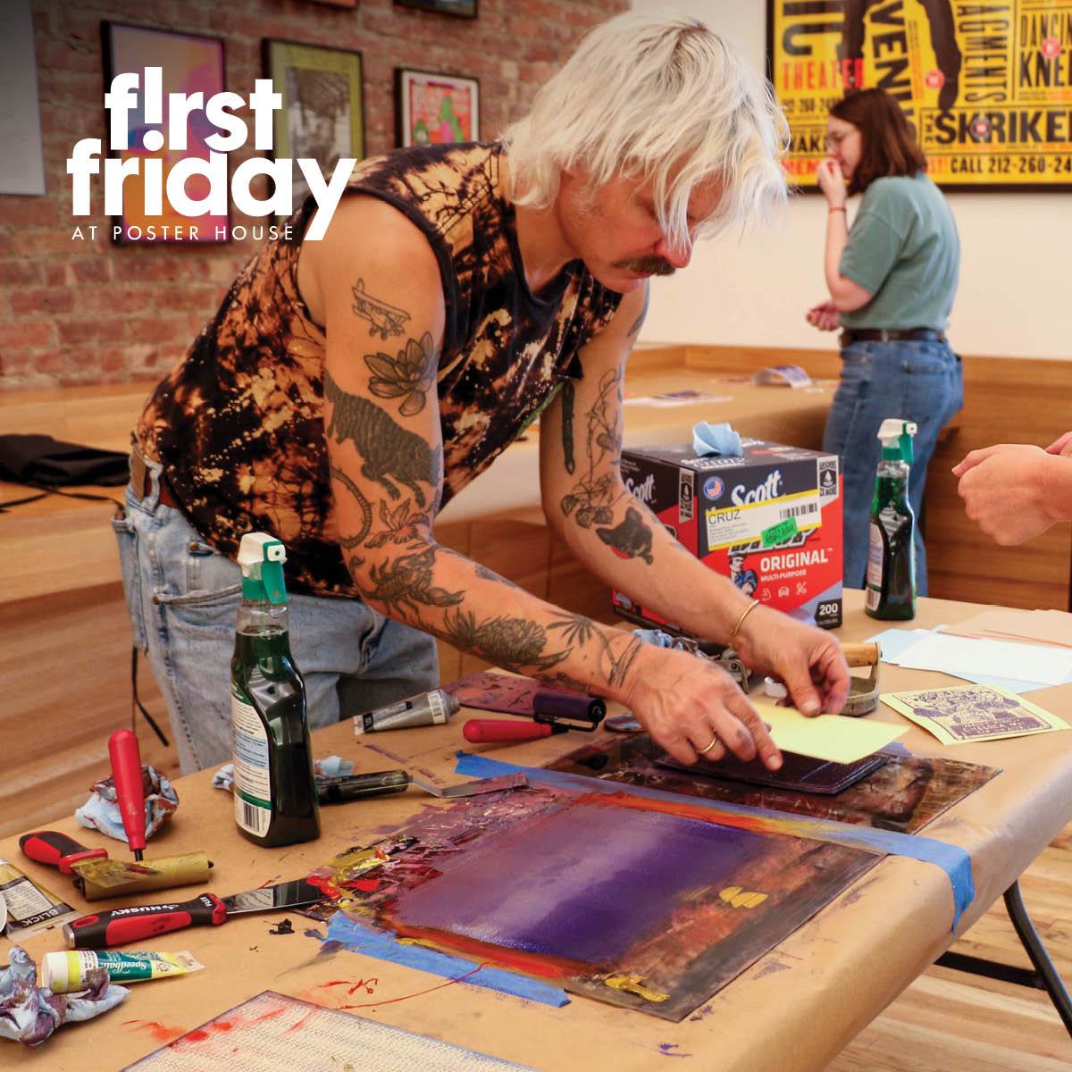 a man standing at a table demonstrating linocut printmaking