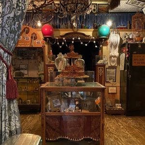 A room crowded with antique knickknacks and curio cabinets.