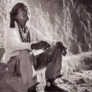 a man sitting on a rock with his eyes closed and a blissful expression on his face