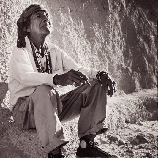 a man sitting on a rock with his eyes closed and a blissful expression on his face