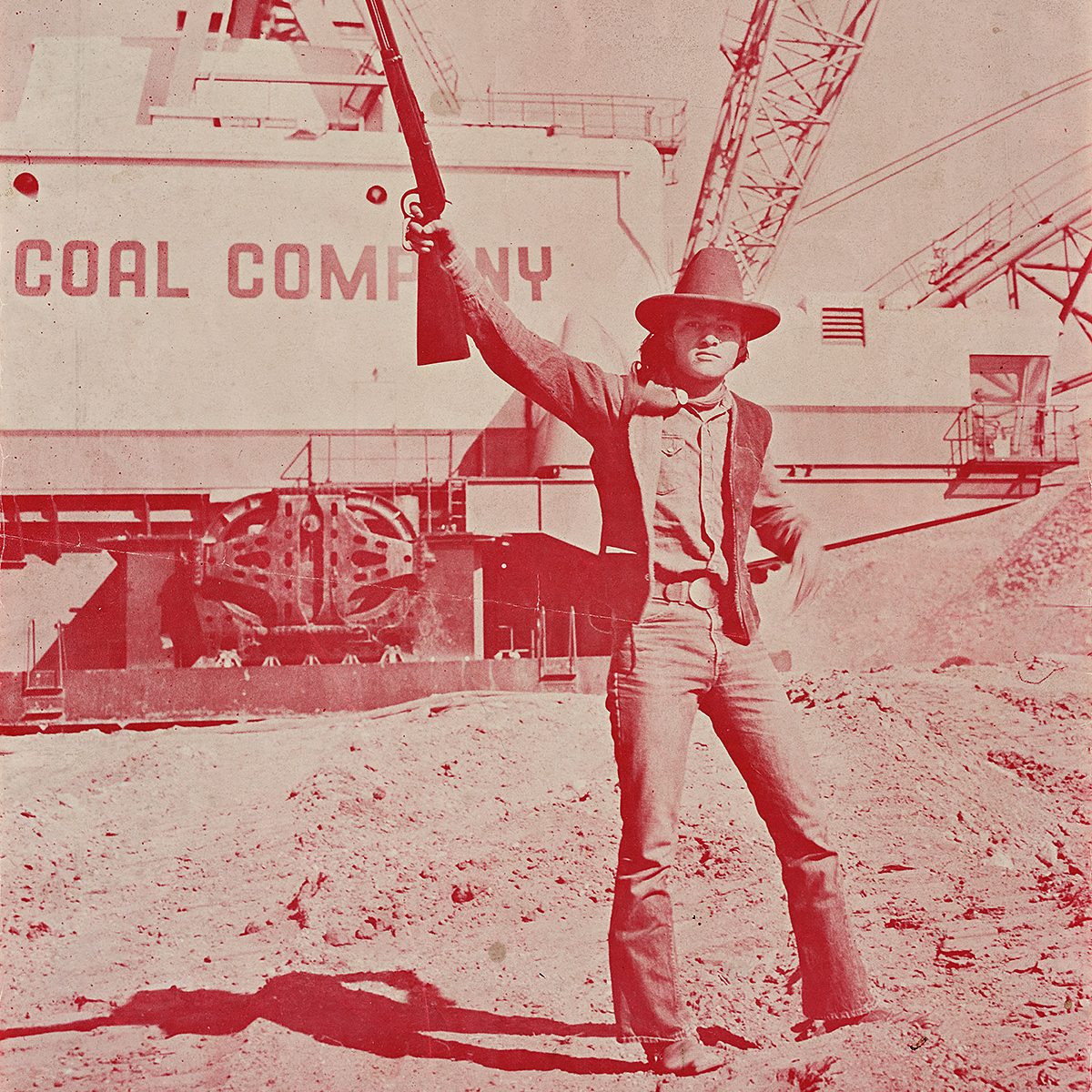 A man in holding up a shotgun in one hand.