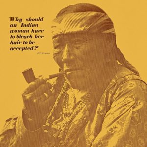 A poster with a photograph of an older Native American woman with braided hair smoking a pipe.